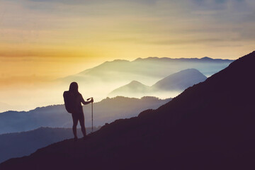 Silhouette of female hiker enjoying sunrise view