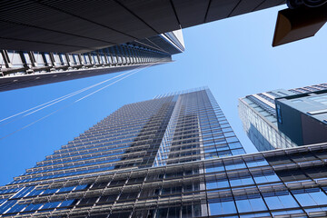 Buildings towering against a blue sky with lots of glass steel and concrete