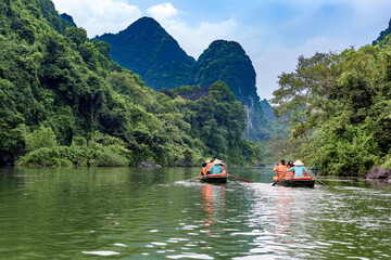 A rowing boat carrying tourists on the river in Trang An, Ninh Binh province, Vietnam. Trang An is a world cultural and natural heritage recognized by UNESCO