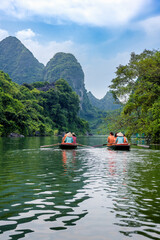 A rowing boat carrying tourists on the river in Trang An, Ninh Binh province, Vietnam. Trang An is a world cultural and natural heritage recognized by UNESCO © ducvien
