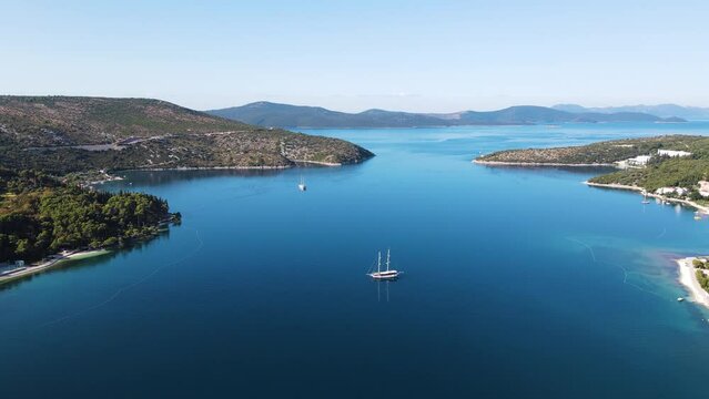 Aerial view of a small sailing boat navigating the blue water on Mediterranean Sea in Slano, Dubrovnik, Croatia.