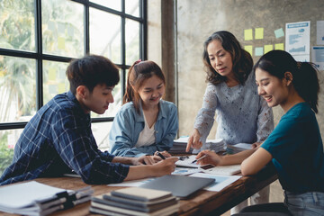 Asian business group holds consultations with senior supervisors on business planning, investment and market analysis for business development. There are various analytical documents and our laptops.