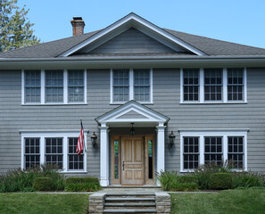 Front  of traditional two story suburban clapboard house with portico entrance