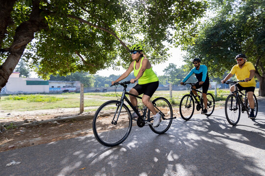 Confident cyclists riding bicycle on countryside road

