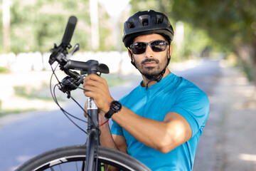 Young man in helmet carrying mountain bike
