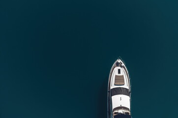 Aerial yacht on calm sea. Luxury cruise trip. View from above of white boat on deep blue water. Aerial view of rich yacht sailing sea. Summer journey on luxury ship.