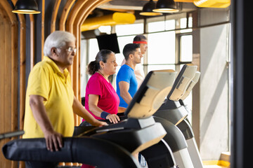 Men and woman in sportswear doing cardio workout at gym
