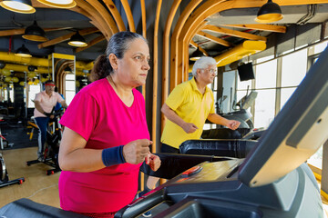 Fototapeta na wymiar Men and woman in sportswear doing cardio workout at gym 