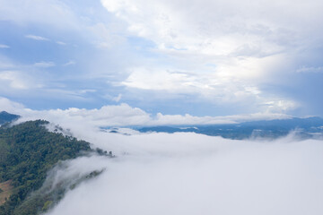 Fototapeta na wymiar aerial view scenery sunrise above the mountain in tropical rainforest..slow floating fog blowing cover on the mountain look like as a sea of mist. .beautiful sunrise in the mist background.