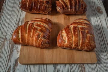 Delicious homemade rich organic buns on a wooden background.