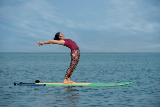 kite surfing in the sea. Woman doing YOGA on a SUP board in the sea. person on the beach. 