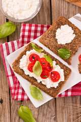 Rye bread with cottage cheese, basil and tomato.