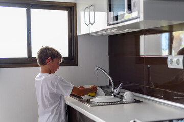 Preteen washing dishes in the kitchen