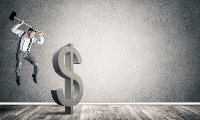 Determined banker man in empty concrete room breaking dollar figure
