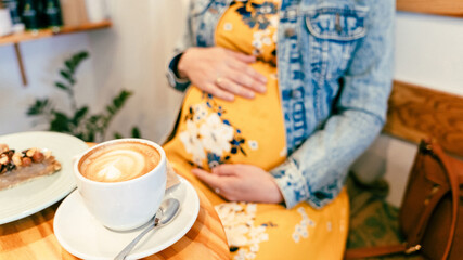 Woman coffee cafe pregnancy drink. Lifestyle morning with happy pregnant girl drink espresso coffee. Concept for coffee product advertising.