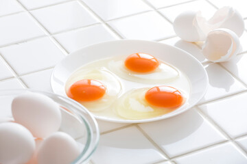 キッチンの白タイルに卵、食材の卵のイメージ　背景