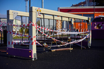 A broken swing on the playground for children. A broken chain on the playground. A broken...