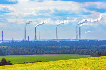 Fototapeta na wymiar Industrial landscape. The pipes of a chemical fertilizer plant emit toxic smoke, carbon dioxide, polluting the air. The concept of transition to green technologies, energy crisis.