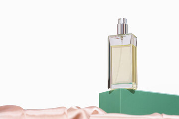 a bottle of perfume on green podium and with silk background. luxury fragrances for women. copy...
