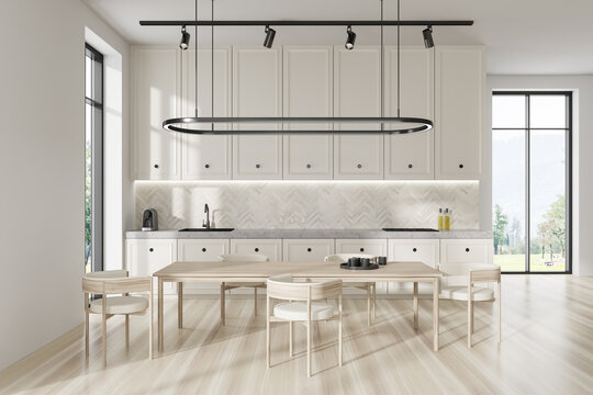 Light kitchen interior with eating table and kitchenware, panoramic window