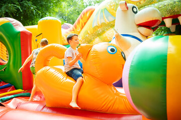 Happy boy having a lots of fun on a colorful inflate castle