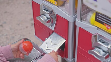 Caucasian Kid Buying Random Toy from Capsule Toy Vending Machine at Amusement Park or Festival Top...