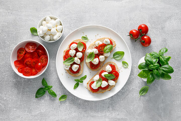Caprese toasts with mini mozzarella cheese, cherry tomato and basil, top view - 533102049