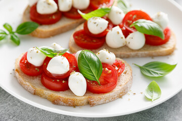 Caprese toasts with mini mozzarella cheese, cherry tomato and basil