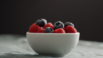 Fresh berries in bowl on linen napkin