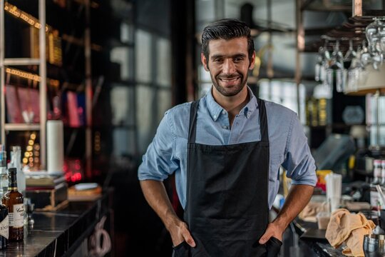 Photo of a handsome bartender behind the bar in a sky lounge bar in Bangkok