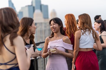 Photo of a group of young elegant businesswomen mingle with each other drinking wine and champagne on a rooftop bar celebrating the successful of company latest deal and hit target goal of the year - obrazy, fototapety, plakaty