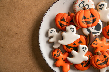 Plate with orange Halloween cookies in the shape of pumpkin ghosts in big plate. Place for text. Top view.
