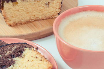 Fresh baked yeast cake with cocoa, cup of cappuccino. Delicious dessert. White background