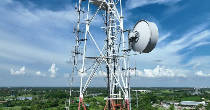 footage of moving out high steel transmitter communication tower with bright blue sky on countryside