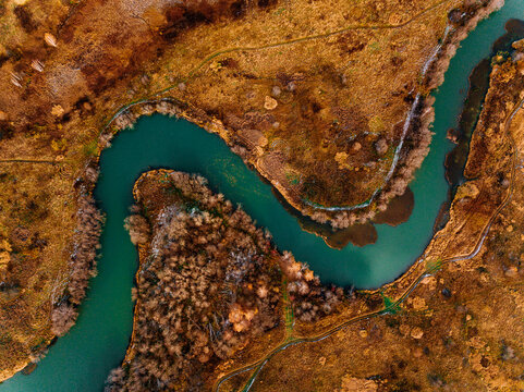 Aerial view of turquoise winding river and golden autumn