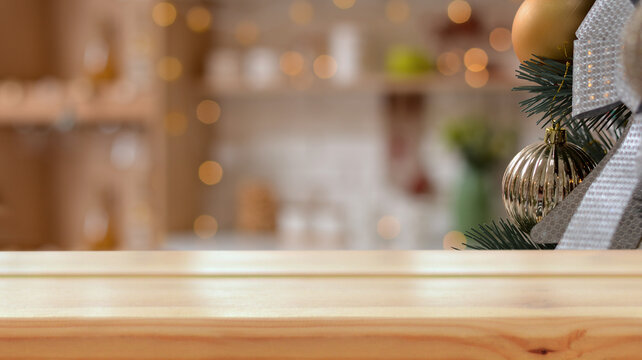 Empty wooden table on the background of a Christmas branch with golden ball, Christmas kitchen ,New Year's golden bokeh. Merry Christmas and Happy New Year! Ready for product montage. Mockup.