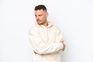 Obraz premium Young caucasian handsome man isolated on white background keeping the arms crossed