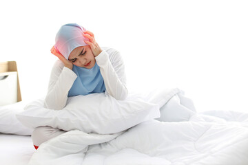 Beautiful and young asian woman in muslim sleepwear with headache emotion sitting on bed. Cute girl touching her head with her hands and feeling painful from Migraine. Healthy concept.