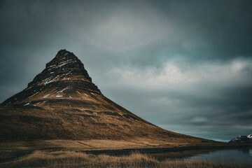 Iceland Mount Kirkjufell with cloudy blue sky and less snow 