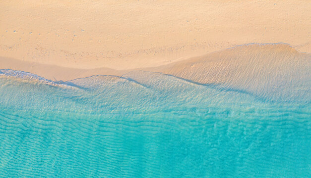 Summer seascape beautiful waves, blue sea water in sunny day. Top drone view. Sea aerial view, amazing tropical nature background. Beautiful bright sea waves surf on bright Mediterranean beach sand