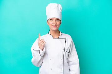 Young caucasian chef woman isolated on blue background pointing with the index finger a great idea