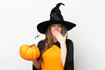 Young pretty woman costume as witch holding a pumpkin isolated on white background happy and smiling covering mouth with hand