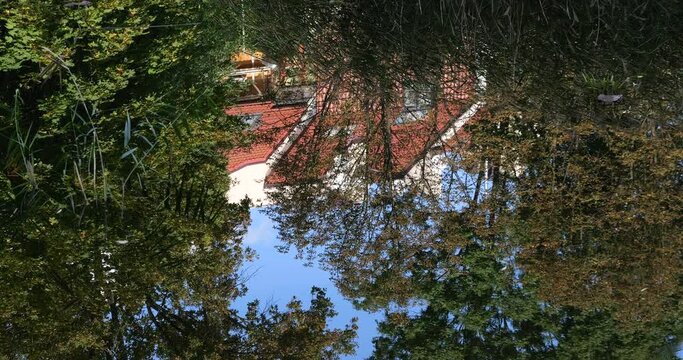 Reflection of the house in the water surface of the pond.