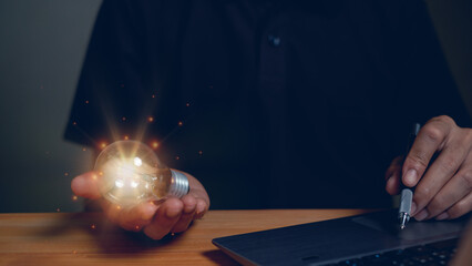 Man touching a bright light bulb, concept of presenting new ideas. Great inspiration and innovation, a new beginning.