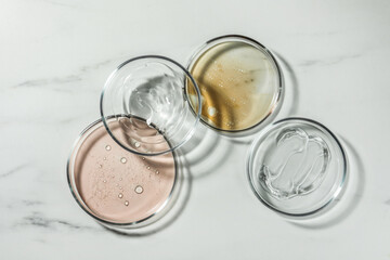 Petri dishes with liquids on white marble table, flat lay
