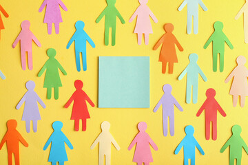 Many different paper human figures around blank card on yellow background, flat lay with space for...