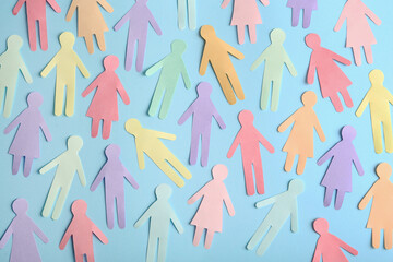 Many different paper human figures on light blue background, flat lay. Diversity and inclusion...