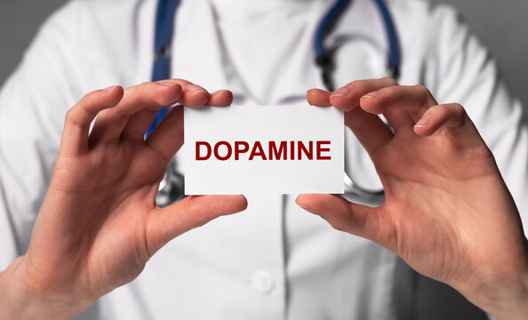 Doctor showing dopamine word. Chemical, hormone role in neurological and physiological functioning. Health care, medicine concept. High quality photo