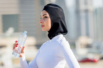 Arabian woman with typical muslim dress training outdoors in Dubai - Middle-eastern beautiful female adult doing fitness outside