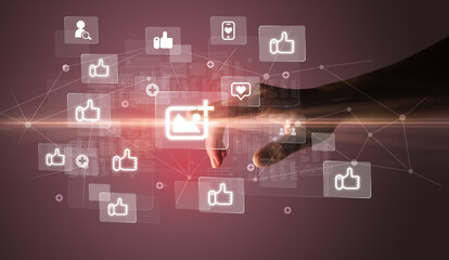Hand pressing social media multimedia application screen with media icons on futuristic concept